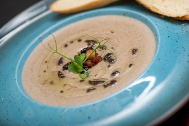 Mantarlı çorba ve beyaz tabakta krema.