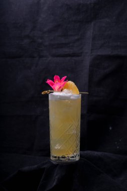 Siyah arka planda ananaslı bir bardak kokteyl ve fotokopi alanı..