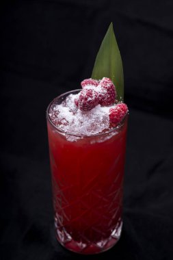 Siyah arka planda bir bardak kokteyl.