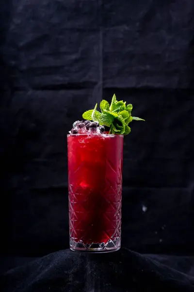 red cocktail with mint, ice and mint.