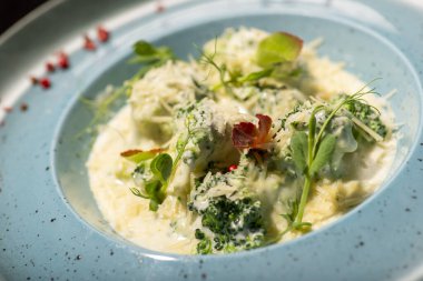 Beyaz tabakta ıspanaklı ve peynirli ravioli.