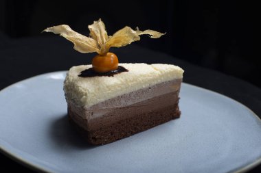 Çikolatalı kek ve siyah bir masanın üstünde bir dilim pasta.