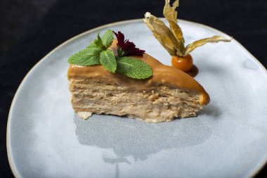 Beyaz bir tabakta çatal ve bıçakla süslenmiş karamel.