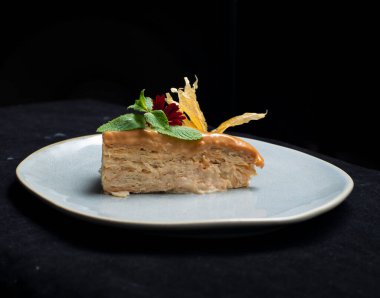 Bir dilim limon, bir tabak ve bıçakla süslenmiş bir parça pasta.