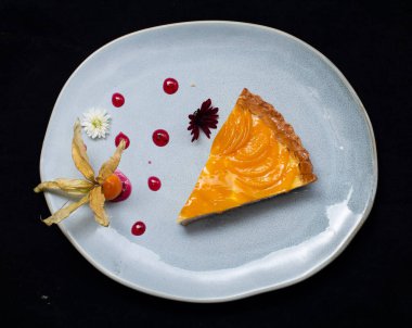 Koyu arkaplanda beyaz tabağı olan bir parça kek.