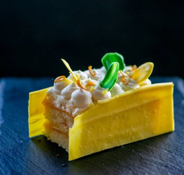 Siyah tabakta mangolu, muzlu ve kremalı kek..