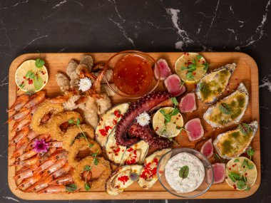 Sofrada soslu ve deniz mahsullü lezzetli balıklar var.