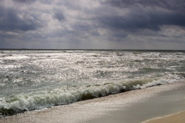 Dalgalar ve bulutlarla dolu güzel sahil