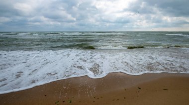 Fırtınalı gökyüzü ile deniz kıyısı.