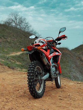 Kırmızı motosiklet yolda.