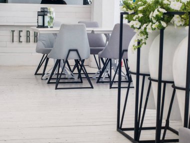 Lokantada beyaz ve siyah masa ve sandalyeler