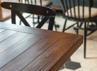 Restoranda boş ahşap masa ve kahverengi sandalye.