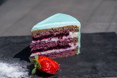 Bir parça çilekli ve naneli yaban mersinli cheesecake.