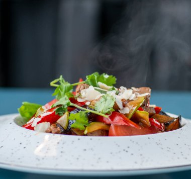 Taze sebzeli salata ve siyah arka planda bir tabakta peynir.