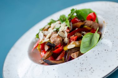 Beyaz tabakta servis edilen lezzetli biftek.