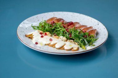 Tavuk göğsü, patates, peynir ve ahşap bir masada taze roka ile nefis bir salata..