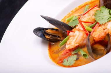 Siyah arka planda beyaz tabakta deniz mahsullü spagetti. İtalyan mutfağı.