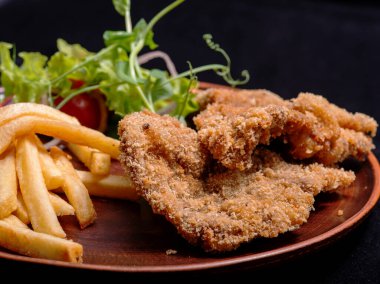 Kızarmış tavuk kanadı, patates salatası ve patates kızartması.