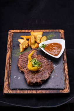 Soslu biftek ve tabakta sebze.