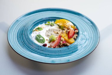 Sağlıklı kahvaltı. Yoğurtlu yulaf ezmesi, taze böğürtlen, tahıl ve meyve..