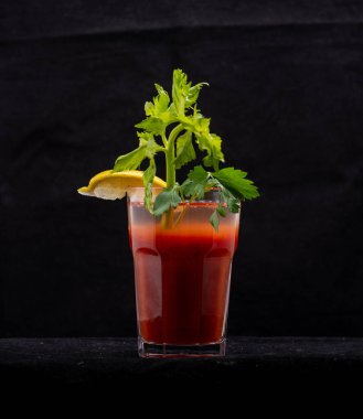 Koyu arkaplanda bir bardak taze meyve suyu, yakın plan.