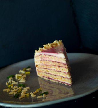 Siyah arka planda pembe ve beyaz kremalı bir parça çikolatalı pasta. Yakın plan, kopyalama alanı, üst görünüm.