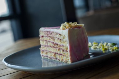 Tahta bir arka planda, beyaz bir tabakta bir parça kek.