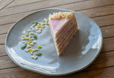 Bir dilim krema ve ahşap bir masada çatal..