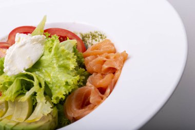 Somon, salatalık, marul, domates ve avokado soslu taze salata. sağlıklı beslenme.
