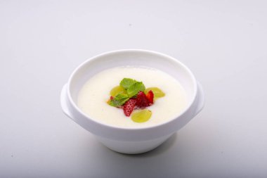 Beyaz arka planda sebzeli ve baharatlı krema çorbası..