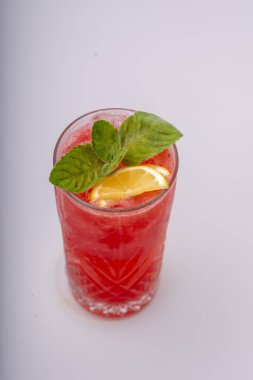 Beyaz arka planda limonlu ve naneli taze kırmızı kokteyl.