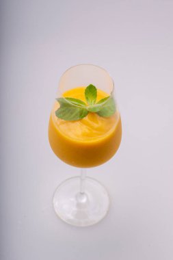 Beyaz arka planda buzlu ve naneli bir bardak taze kabak suyu..