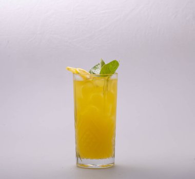 Beyaz zemin üzerinde limon ve portakal suyu olan bir bardak taze kokteyl.