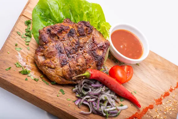 grilled pork steak with sauce and vegetables