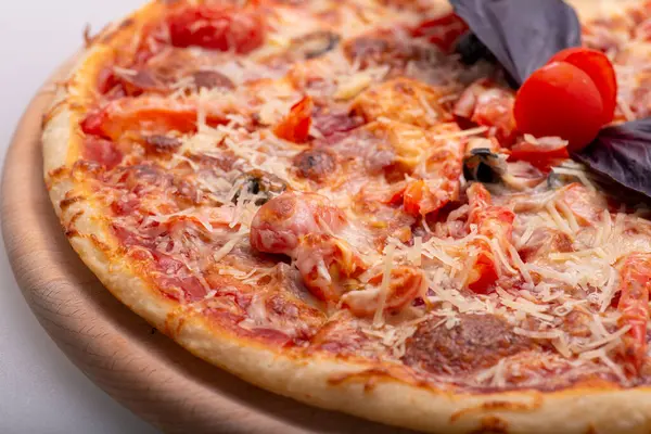 Salamlı, domatesli, mantarlı, peynirli, fesleğenli ve mantarlı lezzetli pizza.