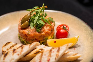 Avokado ve domatesli taze somonlu tartar.