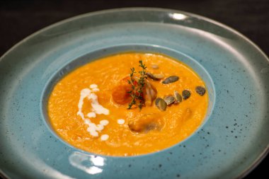 Kremalı balkabağı çorbası, kızarmış ekmek ve tohumlar.