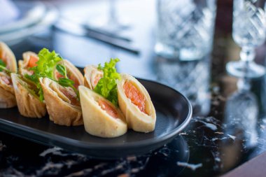 Siyah tabakta taze et ve sebzeli börek.