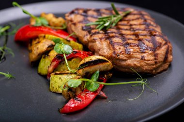 Siyah taş zemin üzerine ızgara sığır eti biftek.