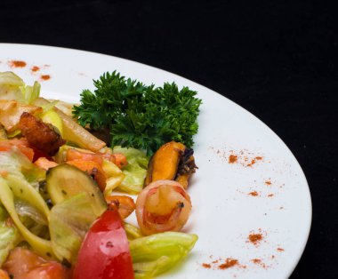 Sebze salatası ve beyaz tabakta et.