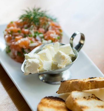 Beyaz tabakta somon ve peynir