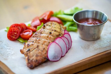 Ahşap arka planda sebzeli ızgara tavuk.