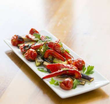 Beyaz bir tabakta taze ızgara bruschetas ve otlar..