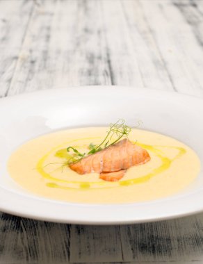 Beyaz tabakta somon çorbası.