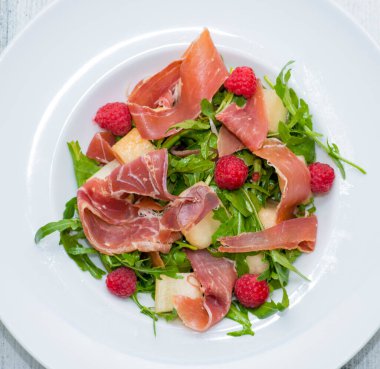 Prosciutto, roka, jambon ve peynirli taze salata.