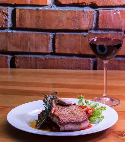 grilled steak served in a white wine with a glass of red wine