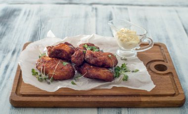 Tahtada soslu kızarmış tavuk kanadı.