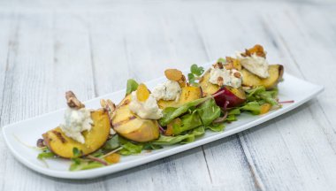 Gri ahşap masada beyaz tabakta mantarlı fırında patates.