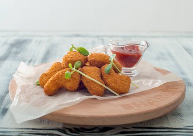 Ahşap arka planda soslu kızarmış tavuk nugget..