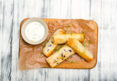 Peynir ve otlar masanın üstünde.